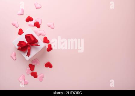 White gift boxes with red ribbon and small red decorative hearts on pink background. Top view with copy space. Valentines day or Wedding romantic conc Stock Photo