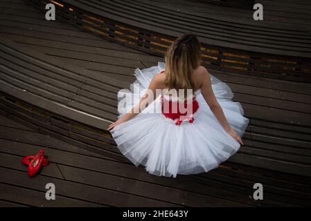 Ballerina wearing christmas white red dress posing on the floor Stock Photo