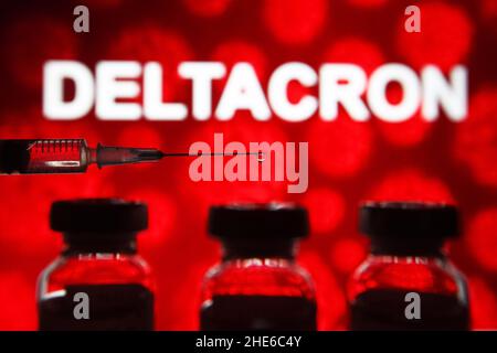 In this photo illustration, a medical syringe and vials seen displayed in front of Deltacron. A new COVID-19 coronavirus variant named Deltacron that combine Delta and Omicron variants has been discovered in Cyprus, reportedly by media. Stock Photo