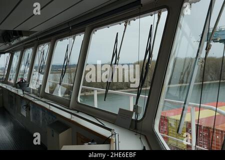View from front windows with windscreen wipers of navigational bridge of container vessel. Stock Photo