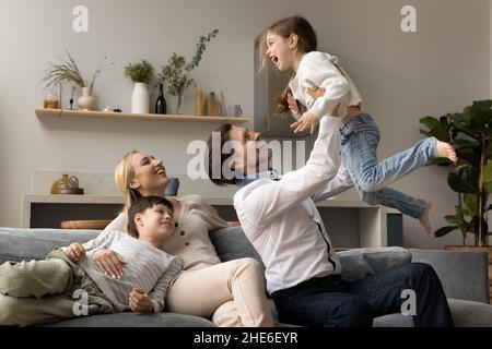 Happy dad lifting cute little excited daughter girl Stock Photo