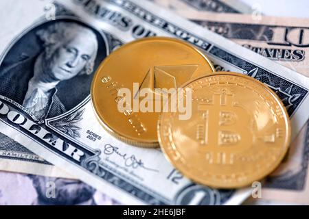 Cryptocurrency coin on top of a US dollar bill Stock Photo