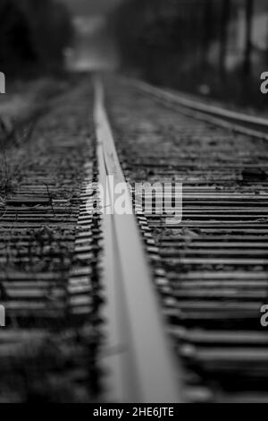 Low angle shot of abandoned railways in grayscale Stock Photo