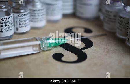 Viersen, Germany - December 9. 2021: Closeup of paragraph symbol with covid-19 vaccination vials and syringe Stock Photo