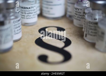 Viersen, Germany - December 9. 2021: Closeup of paragraph symbol with covid-19 vaccination vials Stock Photo