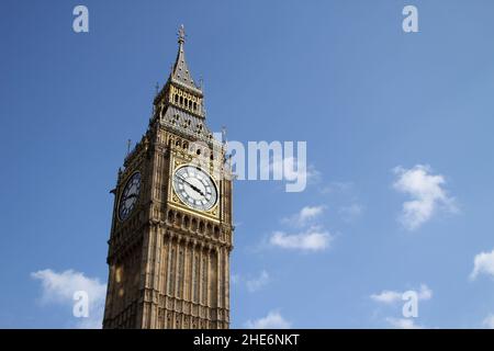 Low angle shot of the Big Ben under a blue sky and sunlight in London, England Stock Photo