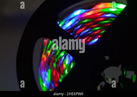 Rolled LED strip lights glow in the dark, close up photo with selective focus Stock Photo