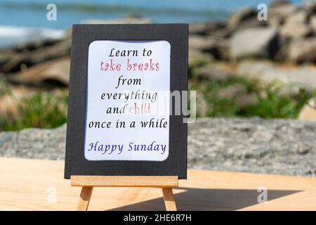Motivational and Inspirational quote on a notepad with blurred beach background Stock Photo