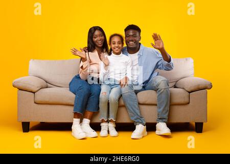 African American family waving hands at camera at studio Stock Photo