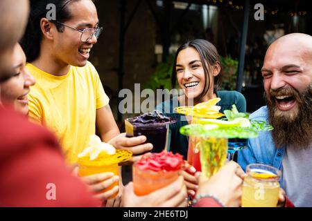 Happy multiethnic group of friends drinking trendy cocktails in a terrace bar  Stock Photo
