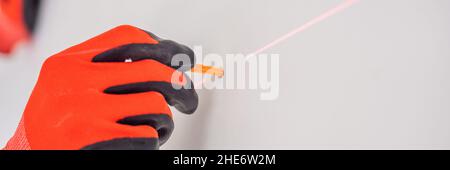 Man twists a screw into the wall BANNER, LONG FORMAT Stock Photo
