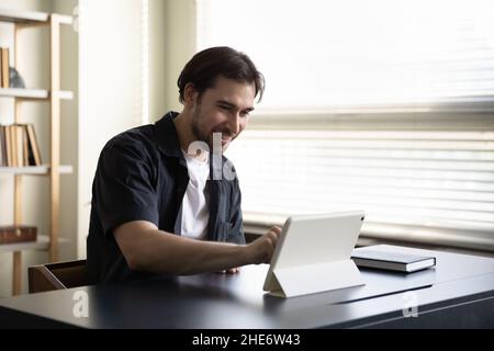 Happy young businessman using digital computer tablet. Stock Photo
