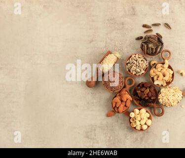 Mixed Nuts in Small Wooden Bowl and Spoon, on Rustic Cement Background. Top View, Copy Space for Text . Stock Photo