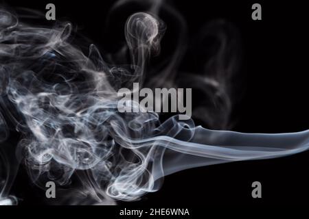 Abstract background of chaotically mixing puffs of smoke on dark