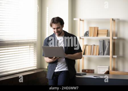 Focused smiling young man working on computer. Stock Photo