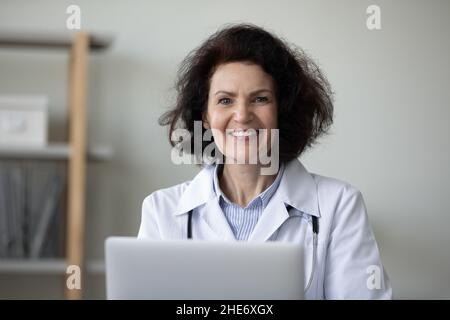 Portrait of smiling trusted older doctor working in office. Stock Photo