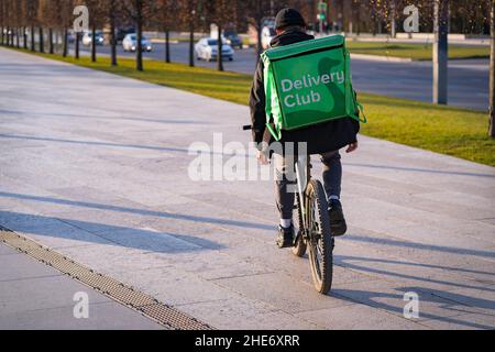 Krasnodar, Russia - January 7 2022: Food delivery boy ride on a bicycle with isothermal bag Stock Photo