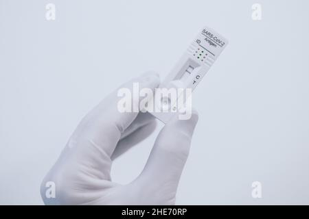 Closeup view of gloved hand with SARS-CoV-2 rapid antigen test nasal. Self test verifies positivity covid-19. Health, healthcare protection, contagion Stock Photo