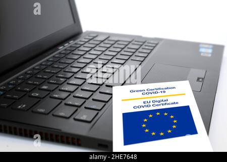 Close-up of the Green Certificate Covid-19 of the European Union paper on the keyboard of a notebook. Stock Photo