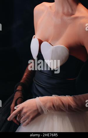 Cropped figure of fashion model woman wearing creative dress with white hearts top and organza gloves. Fashion stylish female clothes concept. Vertica
