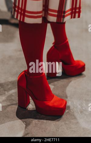 Women's legs in red tights and designer silky high heels. Vertical fashion shot Stock Photo