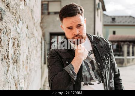 Portrait of a handsome, confident, guy touching his beard Stock Photo