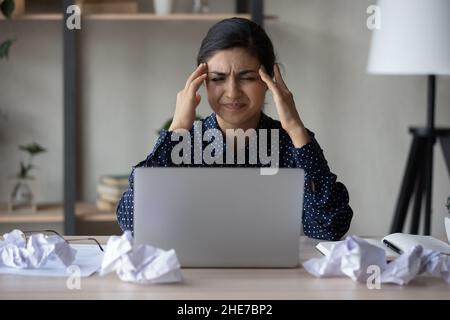 Unhappy annoyed Indian business woman feeling strong headache Stock Photo