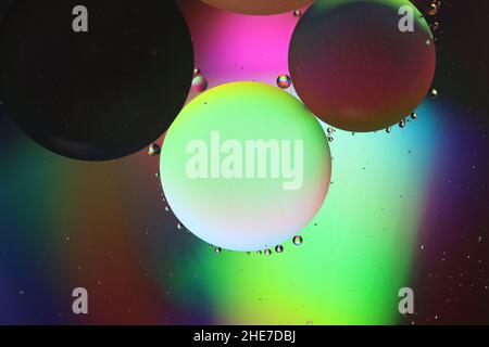 oil droplets on a water surface in front of coloured reflected light, abstract background, macro Stock Photo