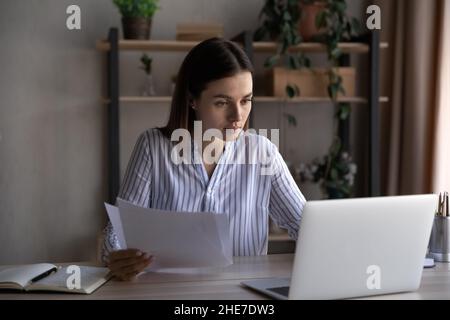 Focused busy young office employee working at laptop Stock Photo