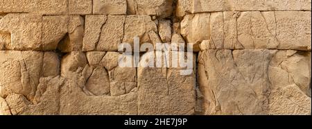 texture of an ancient wall made of huge stone blocks cracked from time Stock Photo