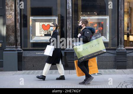 Shoppers carry their luxury brand items from various designer labels whilst out shopping along Old Bond Street, Mayfair, London, England, UK Stock Photo