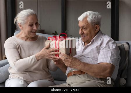Joyful senior man feeling excited getting present from wife Stock Photo