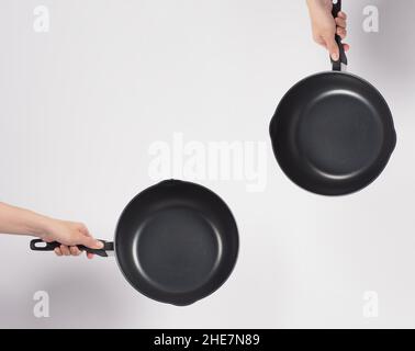 Cleaning Electric non stick pan. Hand on white background cleaning