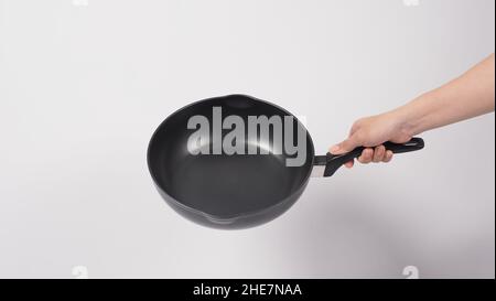 Cleaning Electric non stick pan. Hand on white background cleaning the non  stick pan with handy dish washing sponge which yellow color on the soft sid  Stock Photo - Alamy