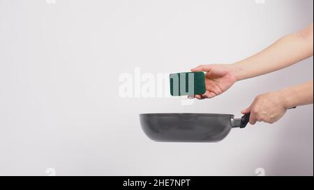 Cleaning Electric non stick pan. Hand on white background cleaning the non  stick pan with handy dish washing sponge which yellow color on the soft sid  Stock Photo - Alamy