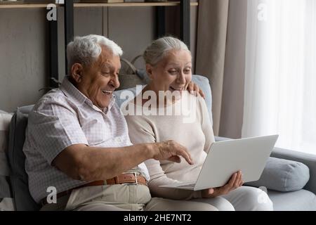 Surprised happy old family couple using computer. Stock Photo