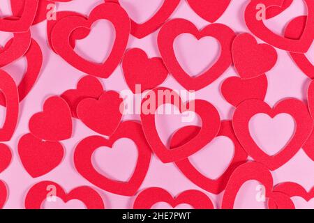 Many heart shaped paper confetti hearts on pink background Stock Photo