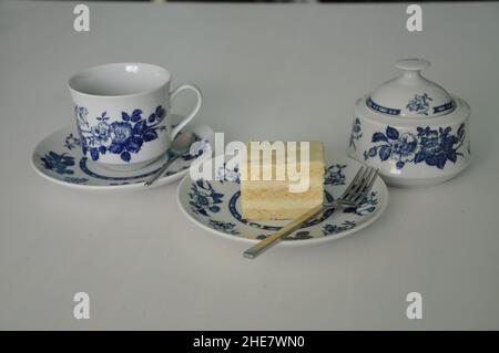 Fine porcelain set for coffee-tea and cheesecake on plate. Old school style tea at five afternoon service cake sweet traditional table, cheesecake sug Stock Photo