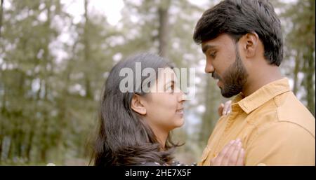 Young Indian couple looking deep into each other's eyes while having a date at a park Stock Photo