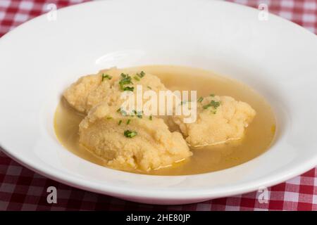 bavarian dumpling soup on tablecloth Stock Photo