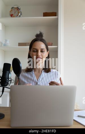 Engaged beautiful female blogger recording audio podcast Stock Photo