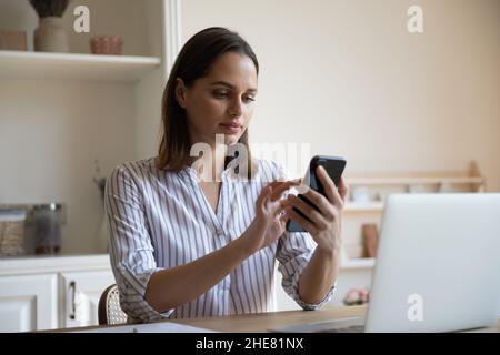 Focused millennial business woman engaged in digital internet communication Stock Photo