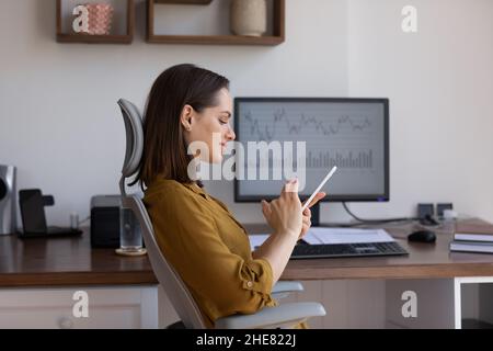 Confident business professional finance trader woman using app on smartphone Stock Photo
