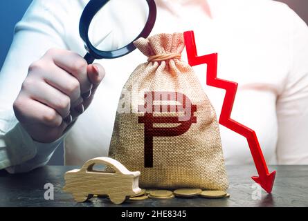 Female surveyor examines a israeli shekel money bag with a red down arrow and auto. ICE. Fuel excise taxes. Falling sales revenue. Electric vehicle su Stock Photo