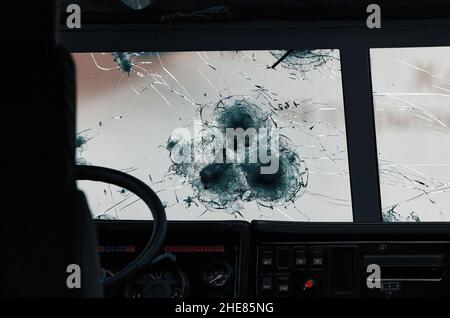 Armored glass after of a direct hit from an automatic weapon. Safety glass after being hit by a bullet. Bulletproof glass armored car after gunshot. Stock Photo