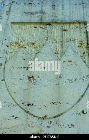 Closeup of a stone wall with carved mountains on it Stock Photo