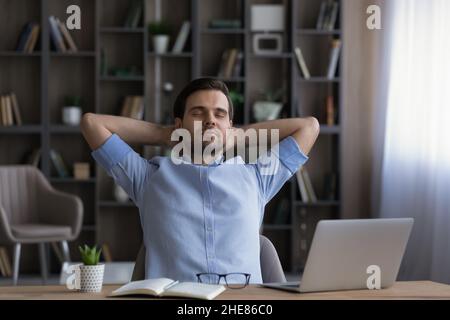Calm businessman leaning back in office chair during break Stock Photo