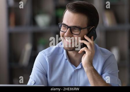 Head shot of smiling man in glasses talking on phone Stock Photo
