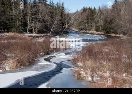 A view of the Sacandaga River in the Adirondack Mountains in winter with snow and ice on the water. Stock Photo