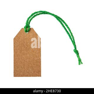Empty cardboard tag  on a green flax twine isolated on white background. Blank brown paper label on a jute ribbon close-up. Copy space. Stock Photo